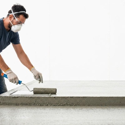 User applying waterproofing solution to concrete surface